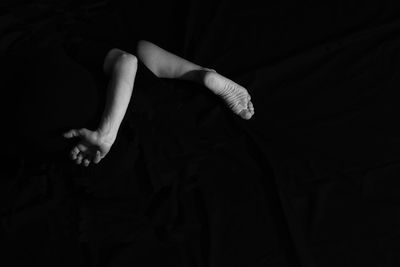 Midsection of woman dancing against black background
