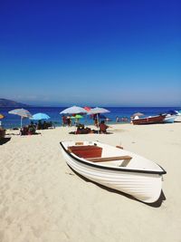 Scenic view of beach against clear blue sky