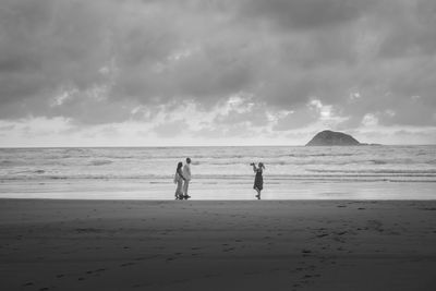 Men on beach against sky