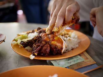 Close-up of person eating food in plate