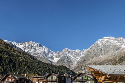 Scenic view of snowcapped mountains against clear blue sky