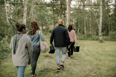 Rear view of people walking in forest