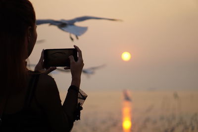 Rear view of woman photographing camera