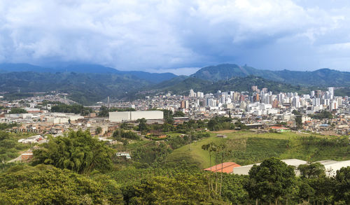Aerial view of townscape and mountains against sky