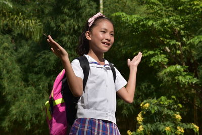 Full length of girl standing against plants