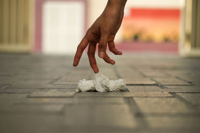 Close-up of hand holding paper on table