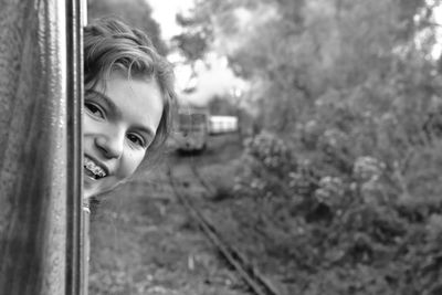 Portrait of smiling girl peeking from train window