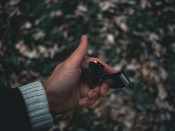 Cropped image of man holding cigarette lighter