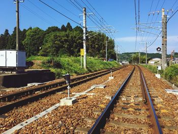 Railroad tracks by trees against sky