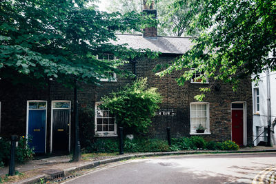 Road amidst trees and buildings in city