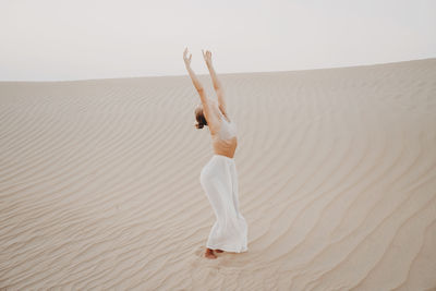 Woman in the desert with arms raised