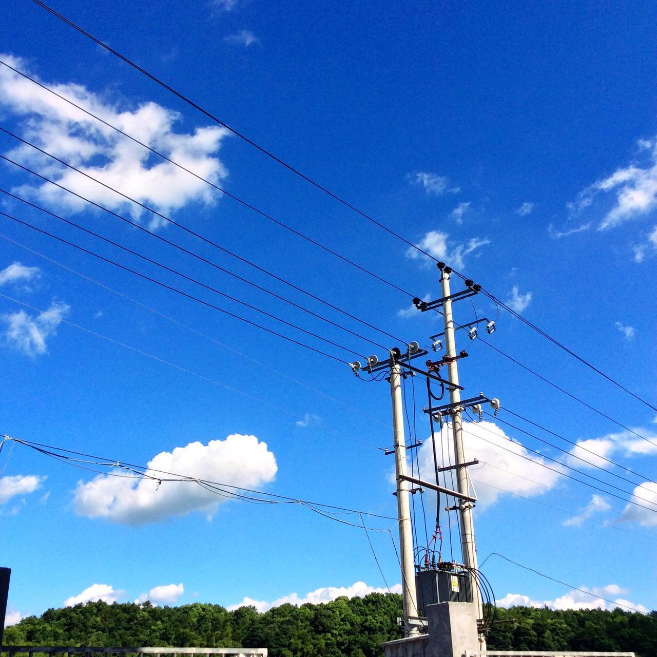 power line, low angle view, cable, power supply, electricity, sky, electricity pylon, connection, blue, cloud - sky, power cable, fuel and power generation, technology, cloud, day, outdoors, no people, cloudy, vapor trail, nature