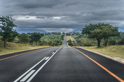Road amidst trees against sky