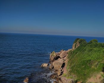 Scenic view of sea against clear blue sky