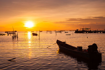 Boat moored in sea against sky during sunset