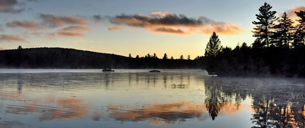 Scenic view of lake against sky at sunset