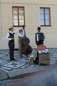 Musicians playing musical instrument on sidewalk