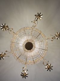 Low angle view of illuminated chandelier hanging on ceiling