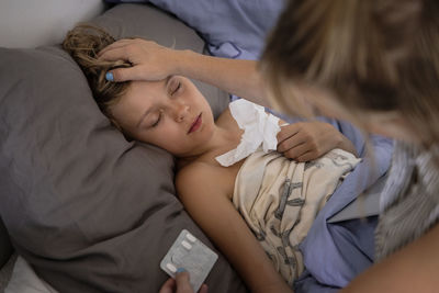 Mother applying medicine to sick boy