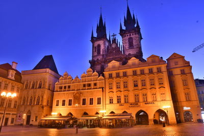 Low angle view of illuminated building against sky at dusk