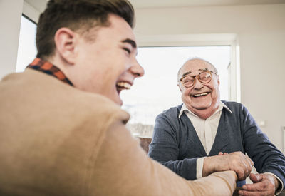 Happy senior man and young man arm wrestling