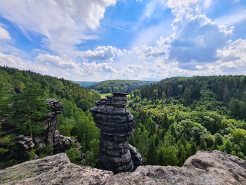 Scenic view of landscape with rocks and forest against sky