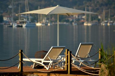 Chairs on table by lake