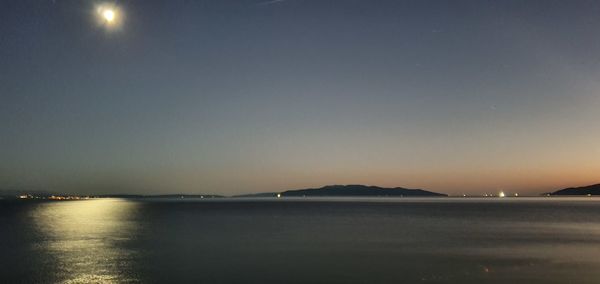 Scenic view of sea against clear sky at sunset