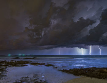 Scenic view of sea against storm clouds