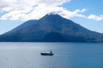 Scenic view of sea and mountains against sky