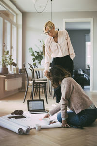 Architects working with design prints on the floor at home