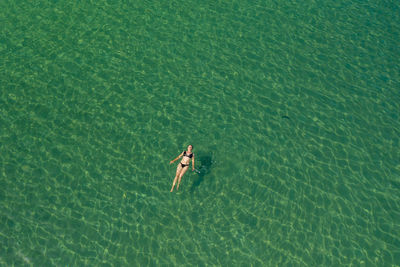 Aerial view of a girl swimming in the adriatic sea, croatia