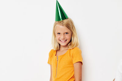 Portrait of young woman standing against white background