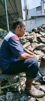 Full length of boy sitting on rock