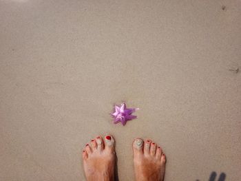 Low section of woman standing by ribbon on beach