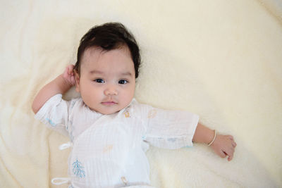 Portrait of cute baby lying on bed