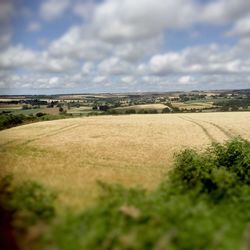 Scenic view of field against cloudy sky