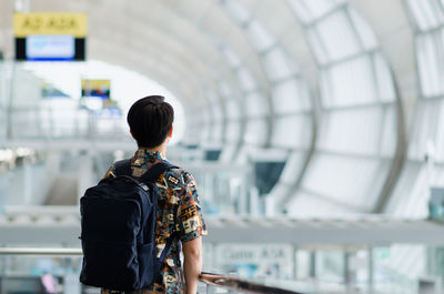 Asian man with carry bag standing and looking forward in the airport. travel and holiday concept.