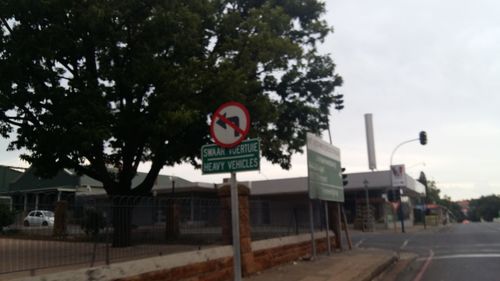 Road sign against sky