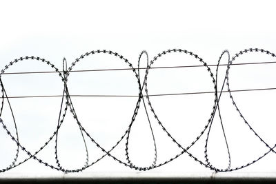 Close-up of barbed wire against sky