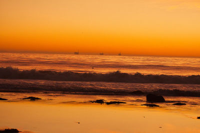 Scenic view of sea against orange sky