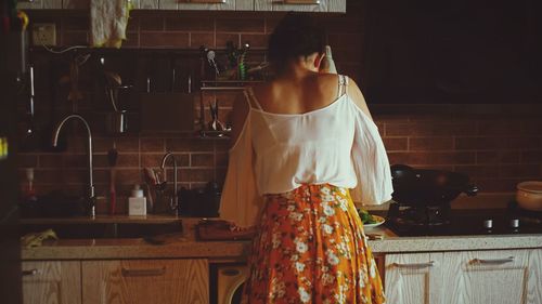 Rear view of woman in kitchen