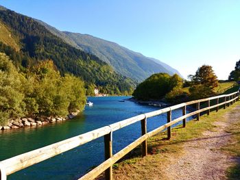 Scenic view of lake and mountains against clear blue sky