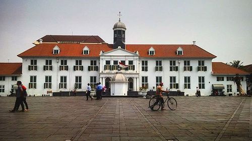 People on street amidst buildings in city