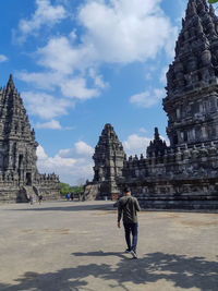 Full length of tourists at temple against building