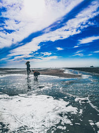 Dog on snow covered landscape against sky