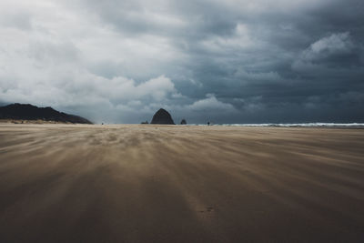 View of desert against cloudy sky