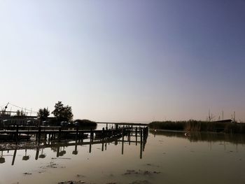 Pier on lake against clear sky