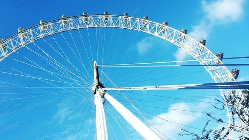 Low angle view of ferris wheel against blue sky