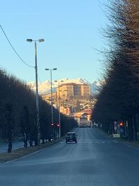 Cars on road in city against sky